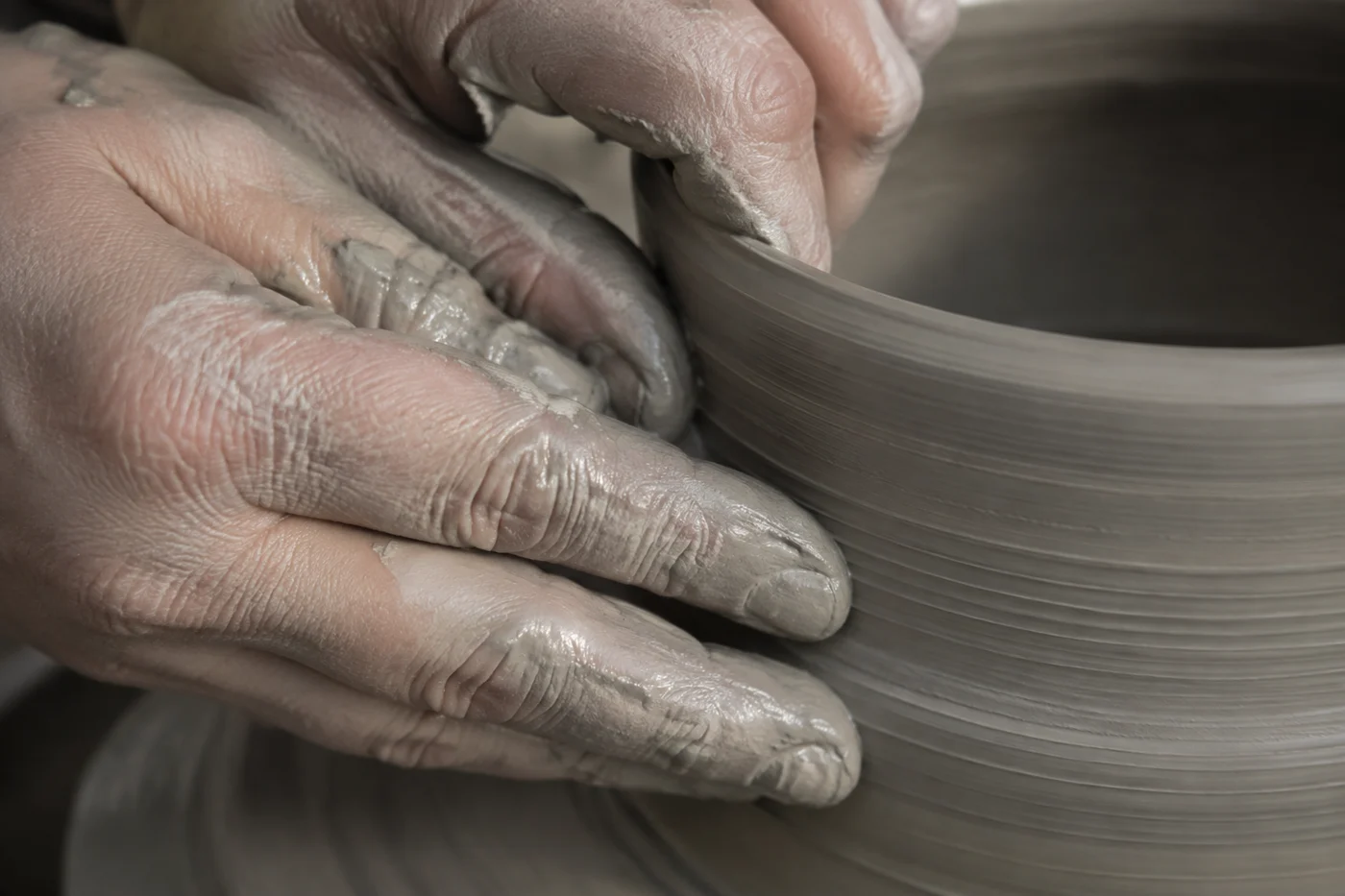 Imagen conceptual de manos trabajando barro en un torno